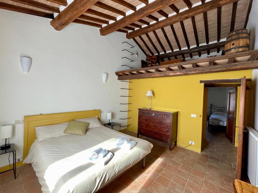 ein Schlafzimmer mit einem Bett in einem Zimmer mit gelben Wänden in der Unterkunft Casale dell'Assiolo Bed and Breakfast in Petrignano sul Lago
