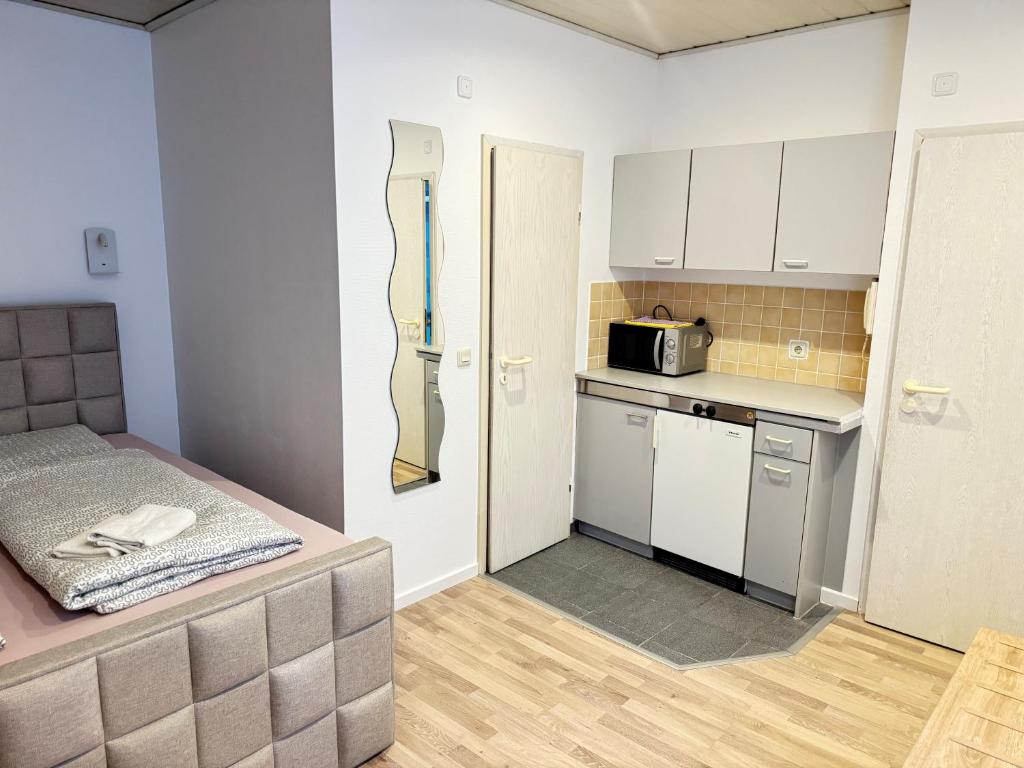 a small kitchen with a bed and a microwave at Pension Sonnenschein in Halle an der Saale