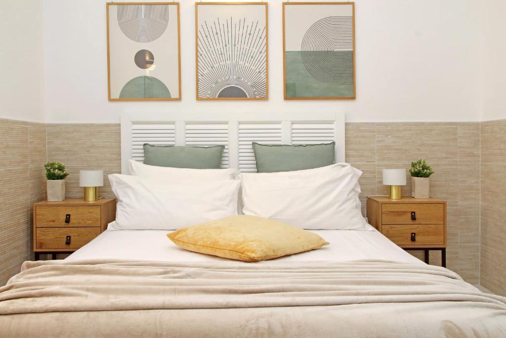 Una cama blanca con una almohada amarilla. en Opera Inn Suites - Rooms and Apartments, en Roma