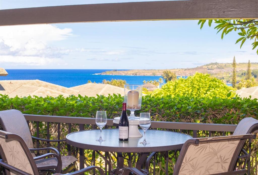 a table with wine glasses and a view of the ocean at 1412 Ridge in Kahana