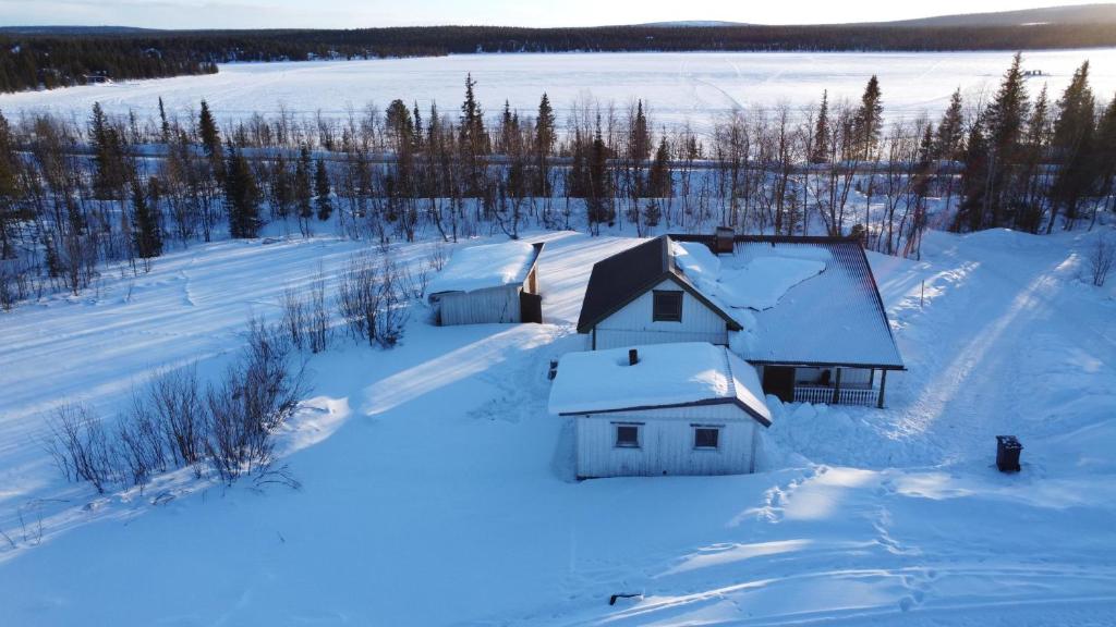 una casa en un campo cubierto de nieve en Arctic Cottage Kiruna, Groups en Kiruna