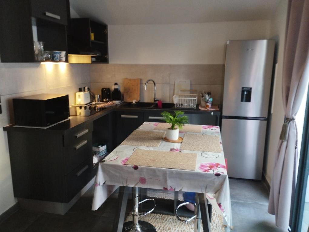 a small kitchen with a table and a refrigerator at T3 Cosy Côté Lagon in Saint-Leu