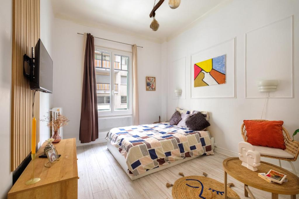 une petite chambre avec un lit et une table dans l'établissement Palais de la paix, à Nice