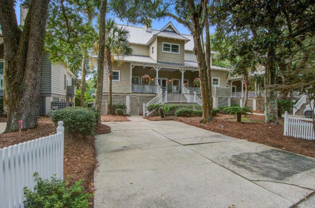 una casa con una valla blanca y árboles en 44 Muirfield Ln, en Kiawah Island