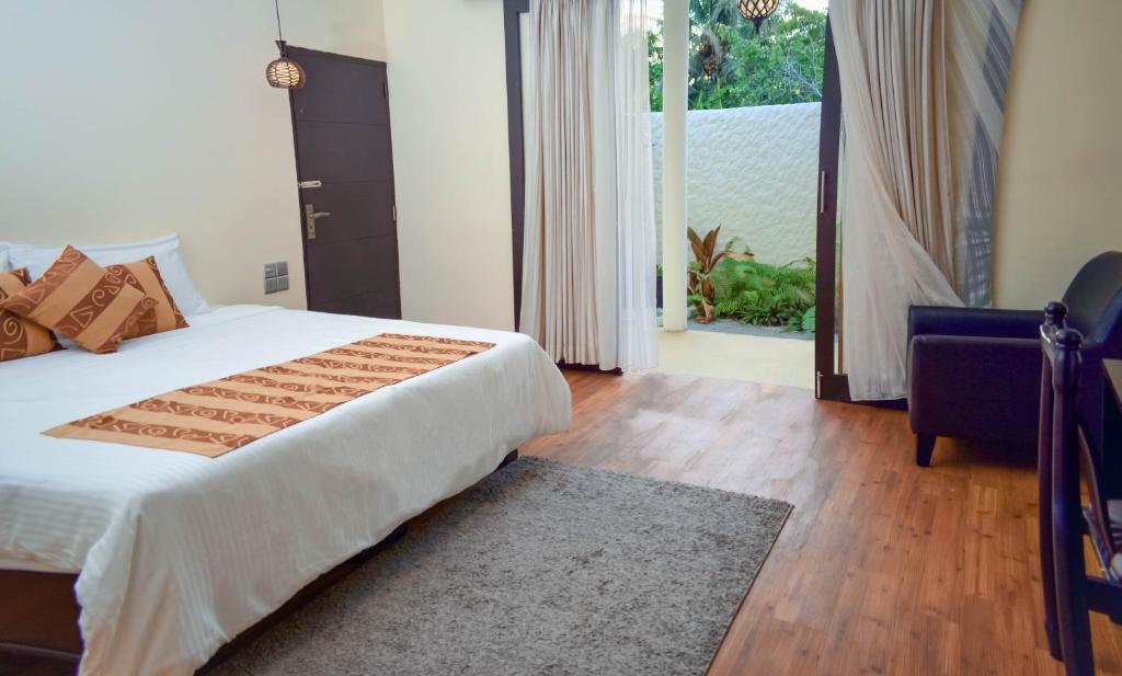 a bedroom with a bed and a door to a patio at Holiday Home Kelaa Retreat in Kelaa
