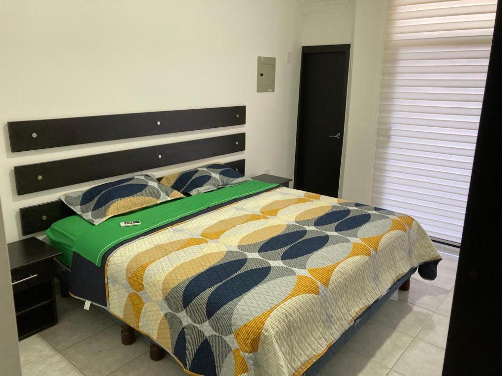 ein Schlafzimmer mit einem Bett mit einer bunten Bettdecke in der Unterkunft Manta (casa ) in Manta