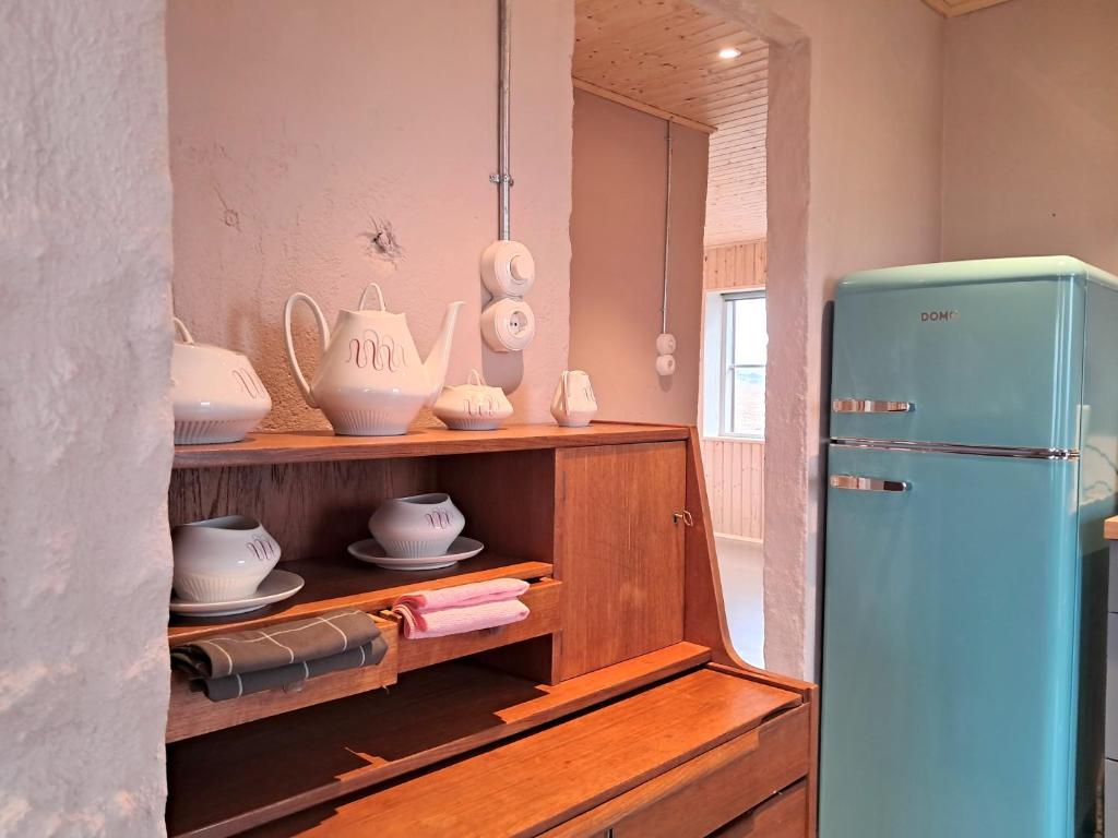 a kitchen with a blue refrigerator and some dishes at The Forgotten Farmhouse in Skogar