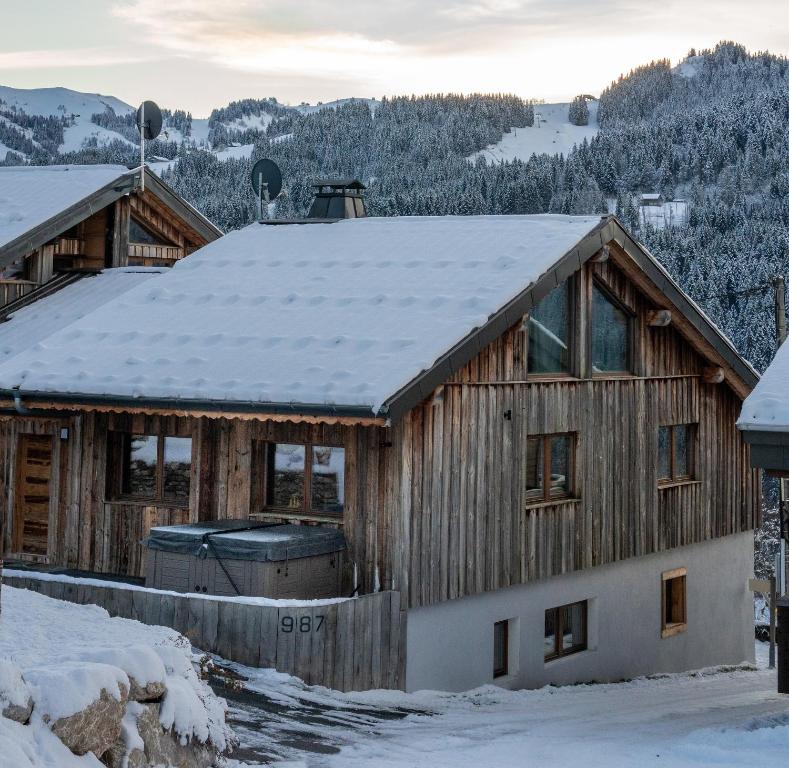 uma cabana com neve no telhado em Chalet Abeille in Les Gets Sleeps 12 em Les Gets