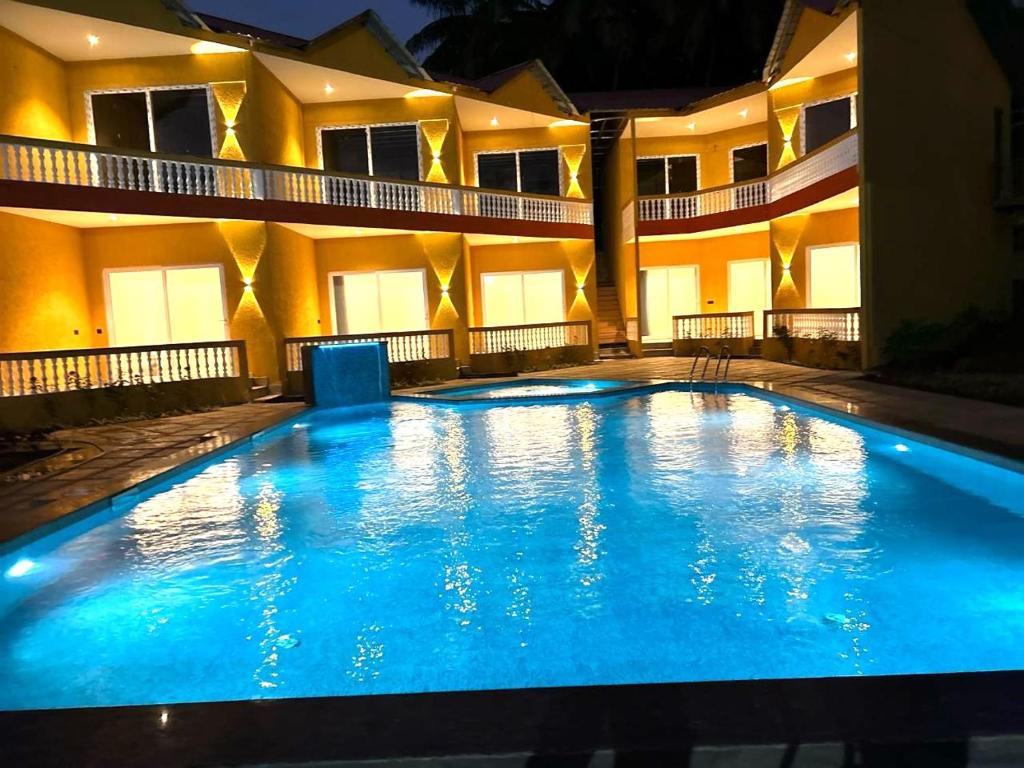 a large swimming pool in front of a building at Eutopia Beach Resort - Boutique Resort with Pool by Rio Hotels India in Morjim