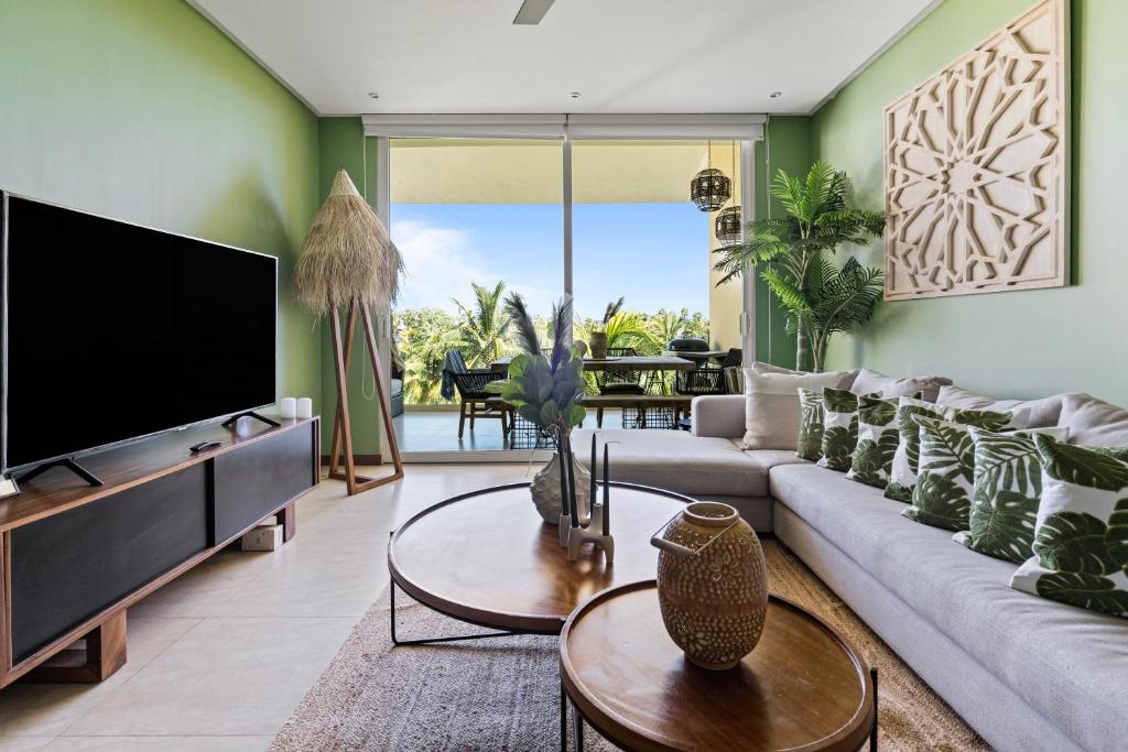 uma sala de estar com um sofá e uma televisão em Stylish Peninsula Golf 3BR Oasis with Pool em Nuevo Vallarta