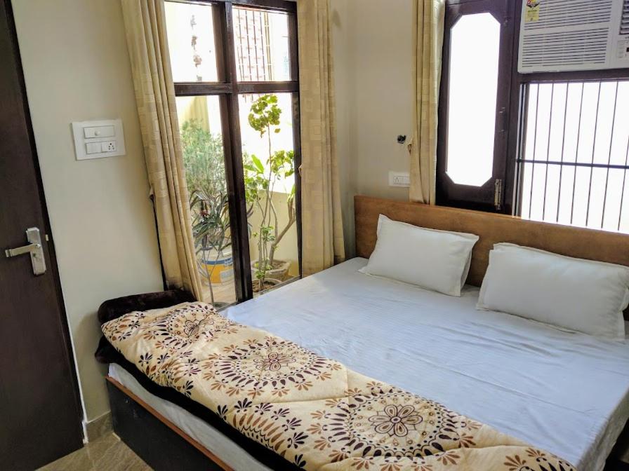 a bed sitting in a room with a window at mye Home stay near golden temple in Amritsar