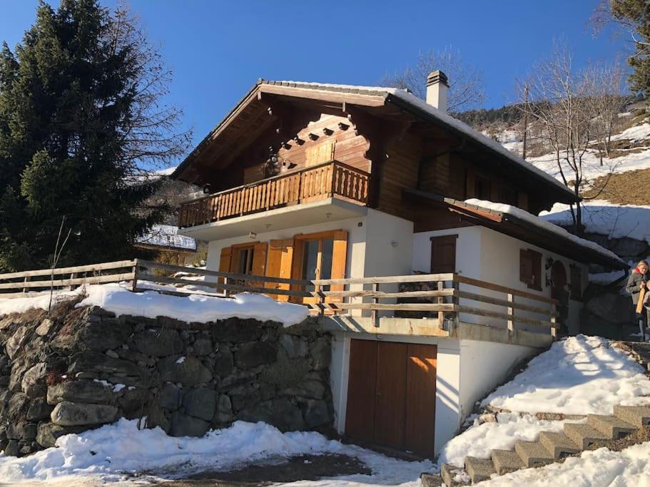 a house with a balcony in the snow at Chalet La Madelon idéal pour les grandes familles in Hérémence