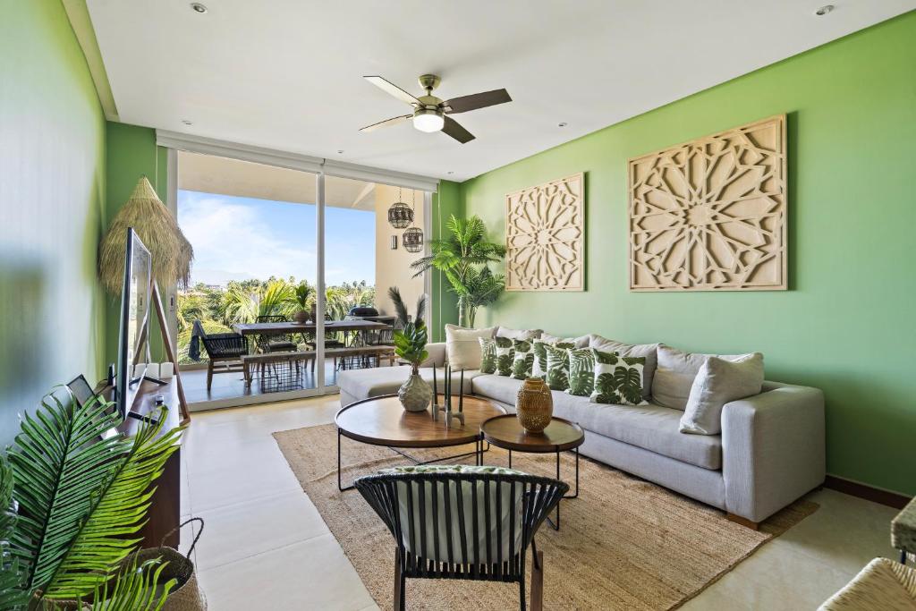ヌエボ・バジャルタにあるStylish Peninsula Golf 3BR Oasis with Poolのソファとテーブルのあるリビングルーム