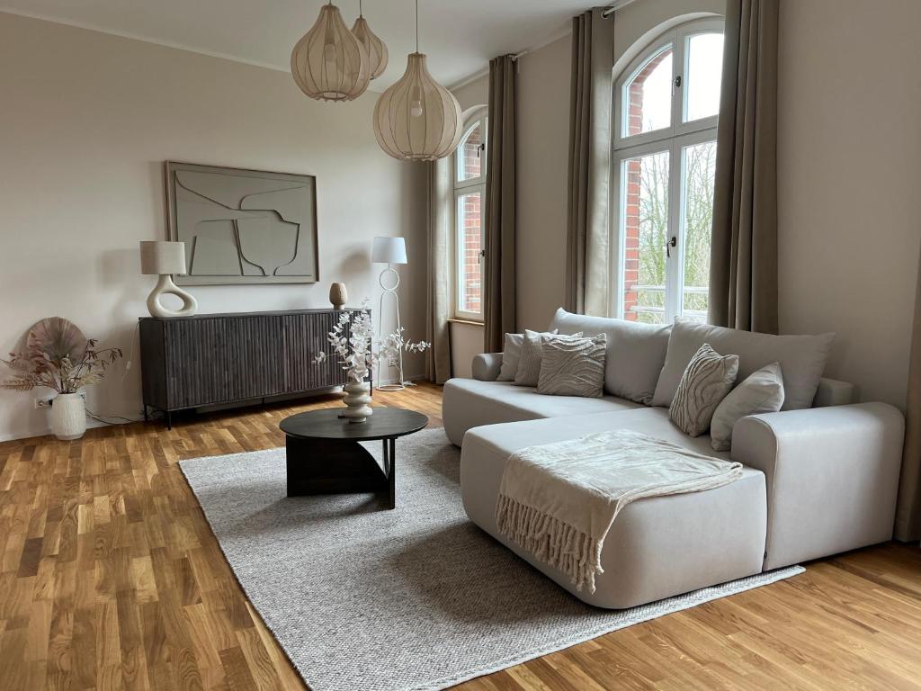 een woonkamer met een witte bank en een tafel bij AMAYA LIVING 80qm Japandi Krefeld Zentrum in Krefeld