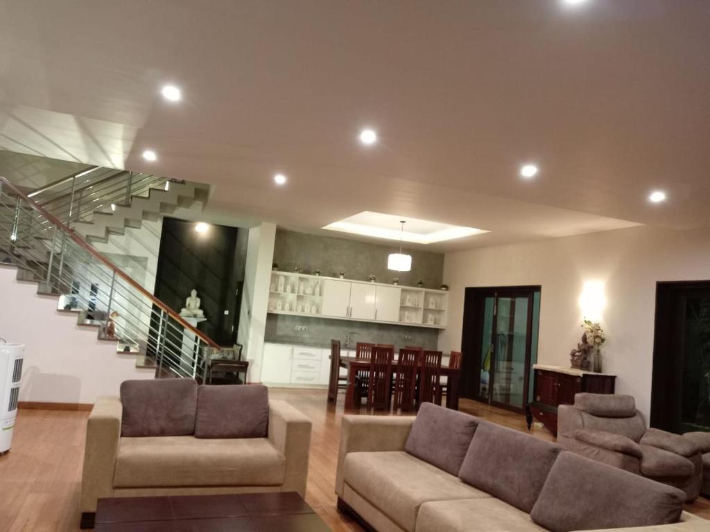 - un salon avec deux canapés et un escalier dans l'établissement Thalangama Lakeview Lodge, à Battaramulla