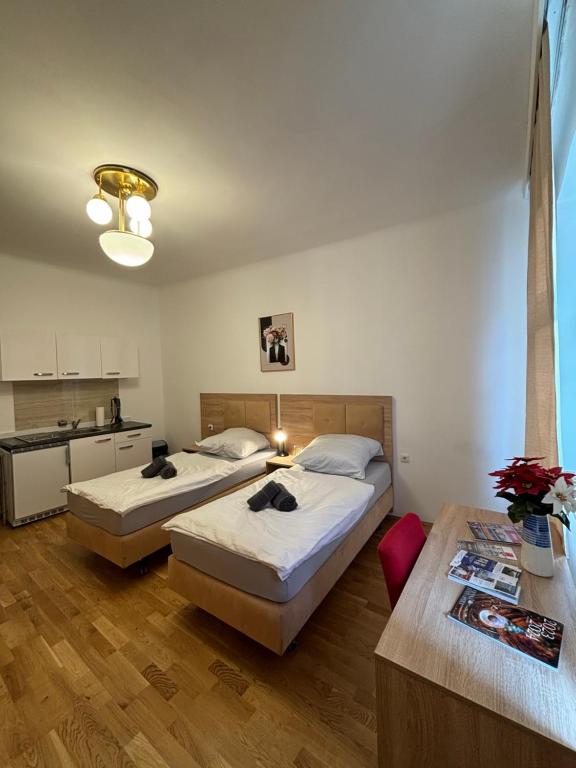two beds in a room with a kitchen and a kitchen at Golden’s Apart-Hotel in Vienna