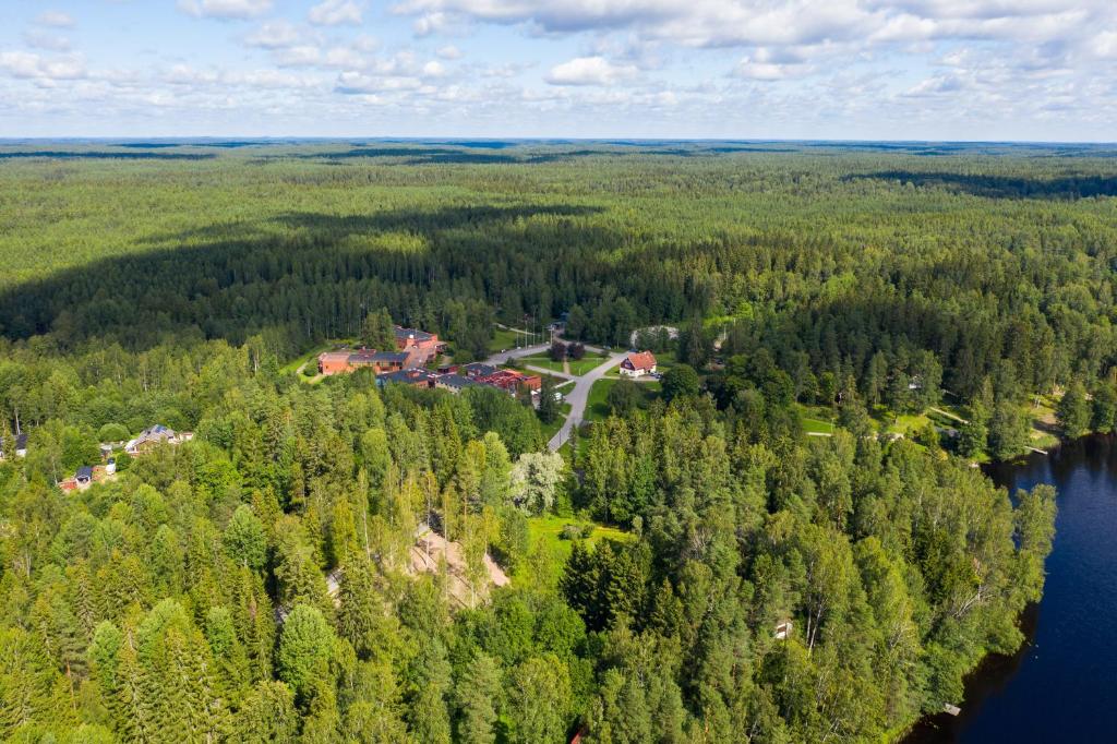 Vue aérienne d'une maison dans une forêt à côté d'une rivière dans l'établissement Hotelli Nuuksio, à Espoo