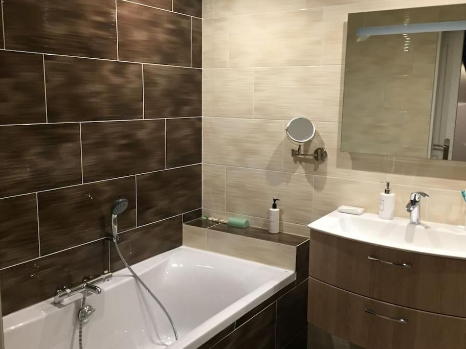 een badkamer met een bad en een wastafel bij Superbe loft climatisé à Suresnes avec terrasse in Suresnes