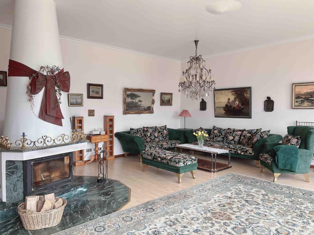 a living room with green furniture and a fireplace at Villa Engelskirchen in Engelskirchen