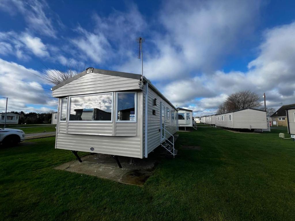 a tiny house sitting in a field of grass at Lovely 6 Berth Caravan At Cherry Tree Holiday Park, Ref 70403c in Great Yarmouth
