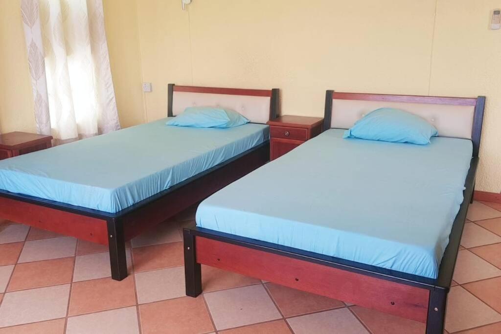 two beds sitting in a room with at Adorable 2bedroom homestay in Beau Bassin