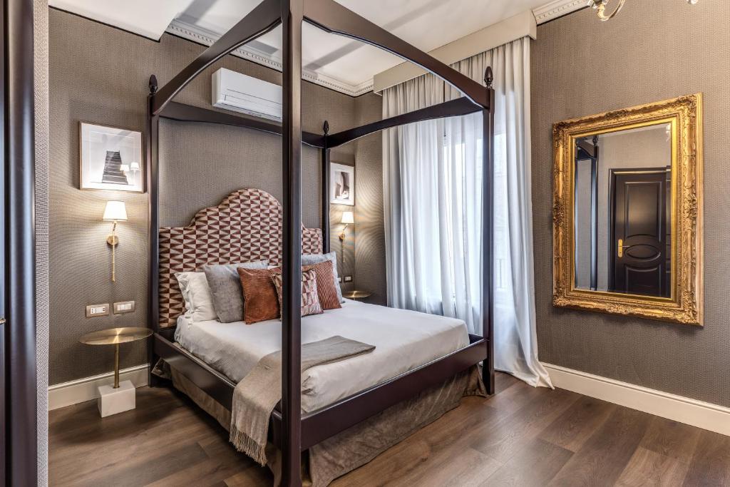 een hemelbed in een kamer met een spiegel bij Antica Residenza Del Corso in Rome