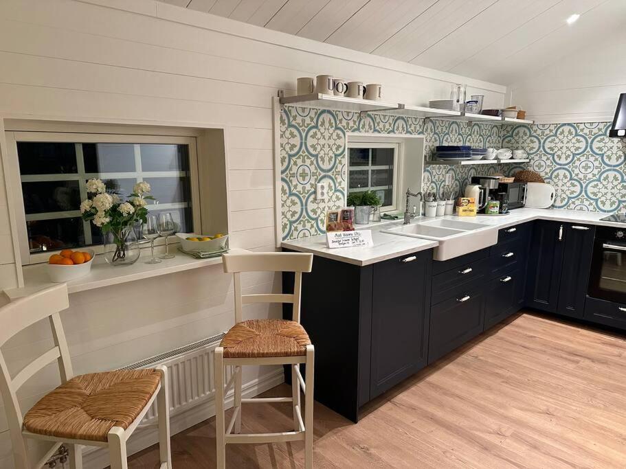 eine Küche mit schwarzen Schränken und blauen und weißen Fliesen in der Unterkunft Bagargården 8 in Åre