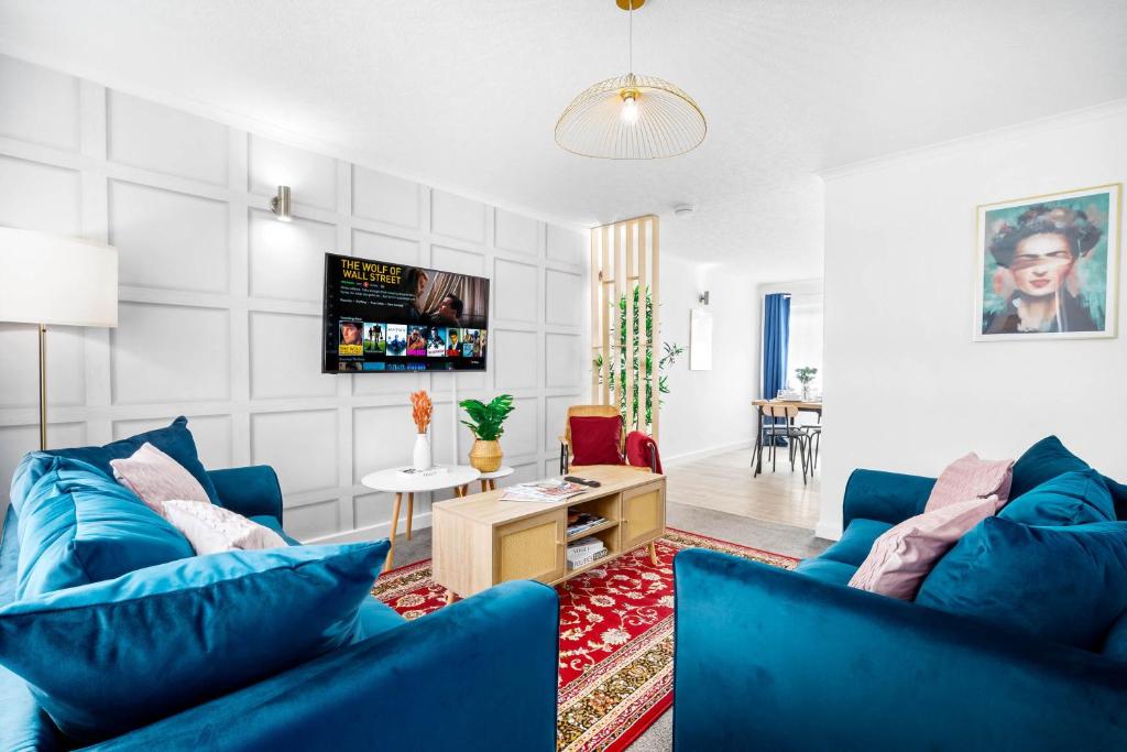uma sala de estar com dois sofás azuis e uma mesa em Unique 2 Bedroom House - Free Wifi & Netflix - Garden - Parking - 4VC em Minworth