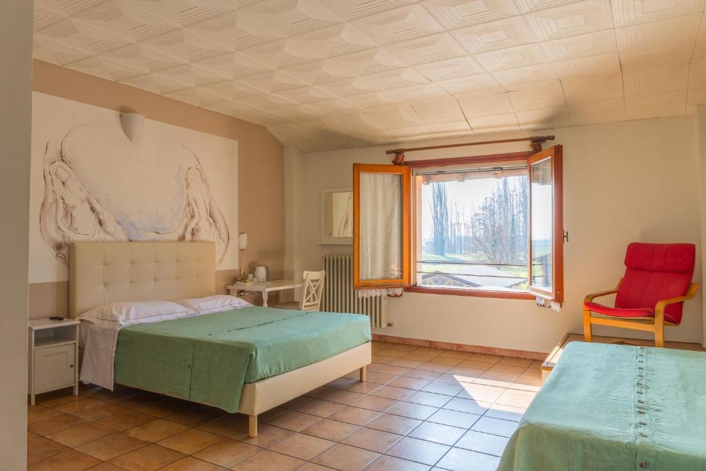 a bedroom with two beds and a window at Hotel Santo Stefano in Campagnola Emilia