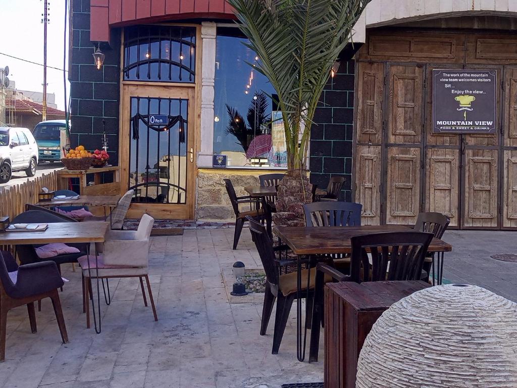 a restaurant with tables and chairs in front of a building at mountain view house in Kerak