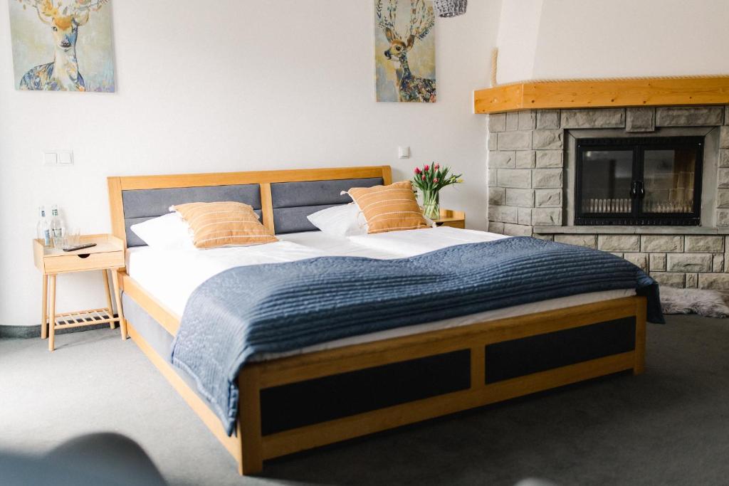 ein Schlafzimmer mit einem großen Bett und einem Kamin in der Unterkunft Parkowe Szczyrk in Szczyrk