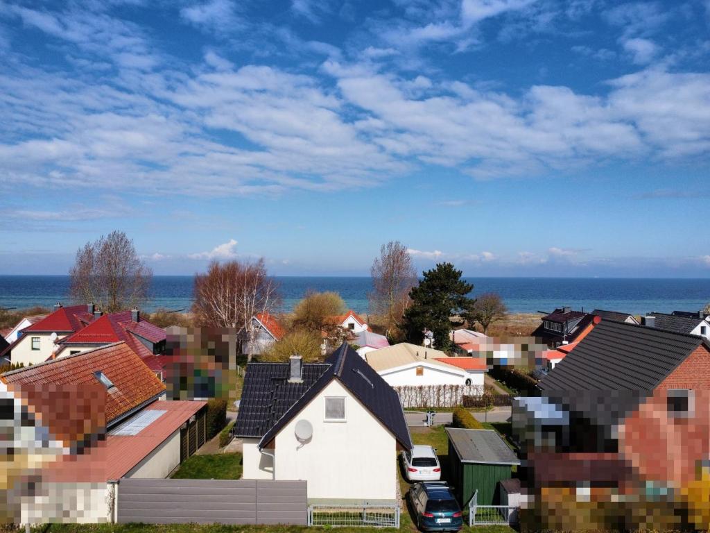 Une petite ville avec des maisons et l'océan dans l'établissement Ferienhaus Meerkieker mit Ostseeblick auf der Insel Poel - b48418, à Am Schwarzen Busch