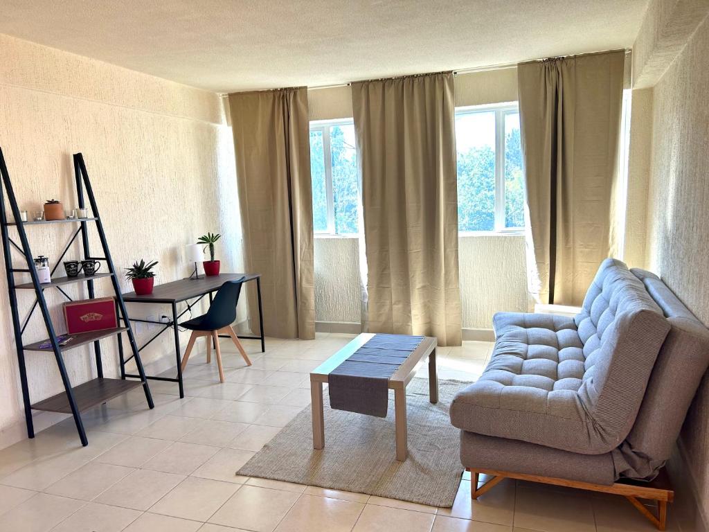 Foro Sol في مدينة ميكسيكو: غرفة معيشة مع أريكة وطاولة