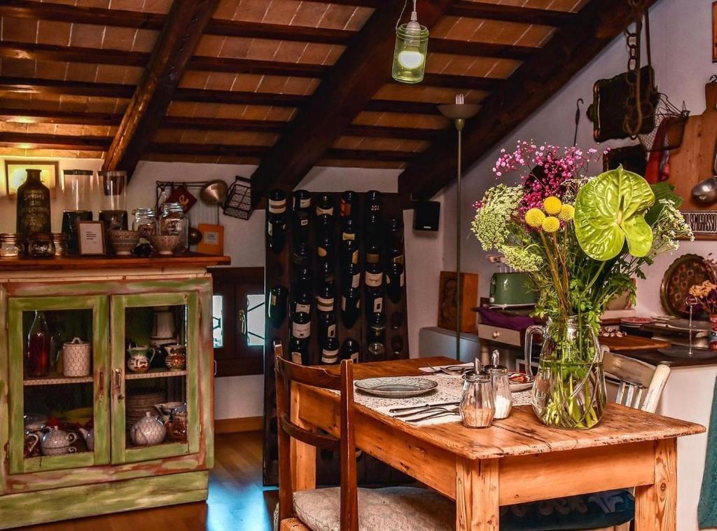 una mesa con un jarrón de flores. en Locanda San Tomaso en Treviso