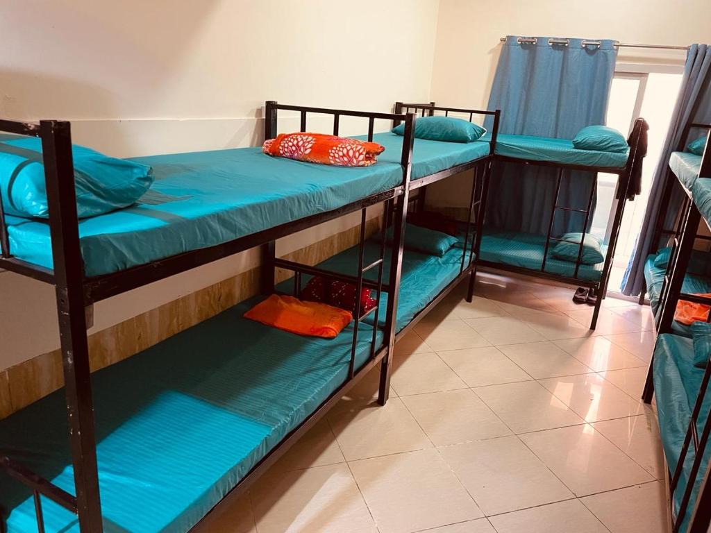 Habitación con 3 literas en una habitación en Happy Hostel, en Dubái
