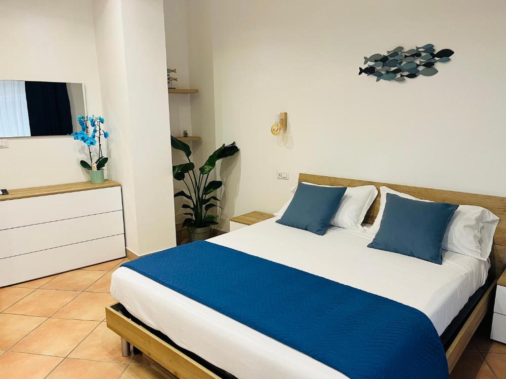 a bedroom with a bed with blue and white pillows at Casa Saline in Tarquinia