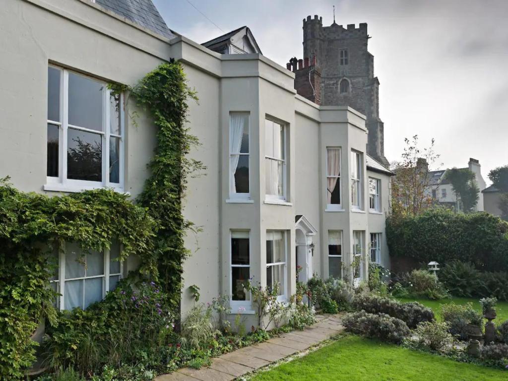 an ivy covered house with a castle in the background at Pass the Keys The Top Space in Hastings