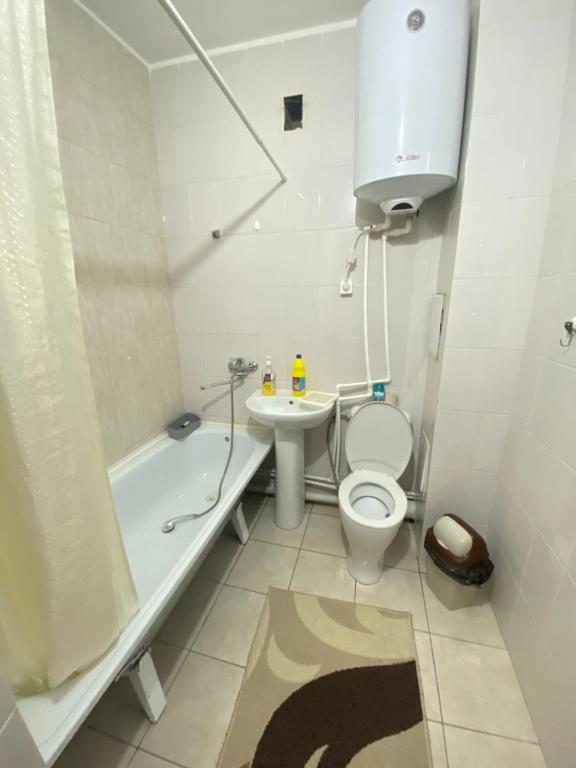 a white bathroom with a toilet and a sink at Квартира in Kokshetau