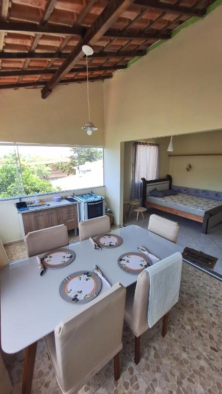 uma sala de jantar com uma mesa e cadeiras e uma cama em casa suite cabo frio em Cabo Frio