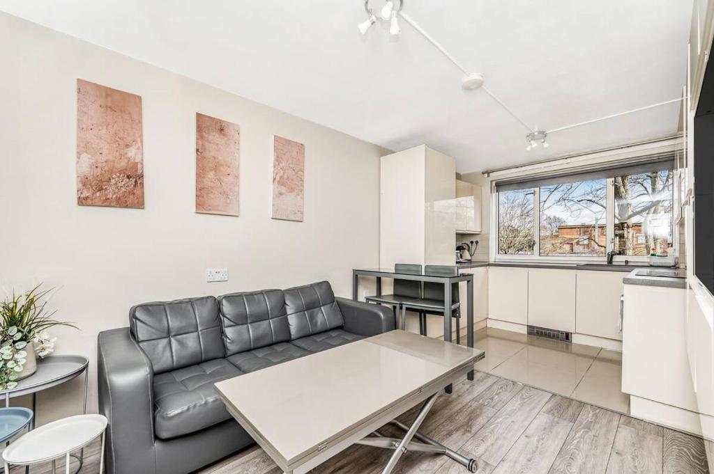 a living room with a couch and a table at Pass the Keys Whitechapel Central Apartment in London