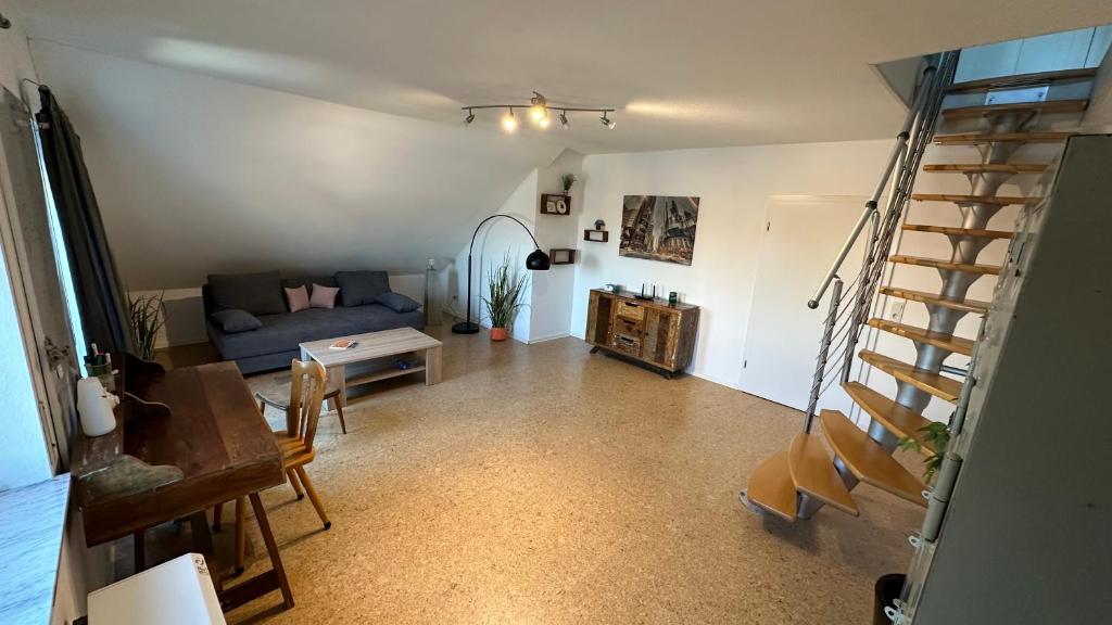 - un salon avec un canapé bleu et des escaliers dans l'établissement 140 qm Maisonette-Whg ruhig und doch zentral, à Florstadt