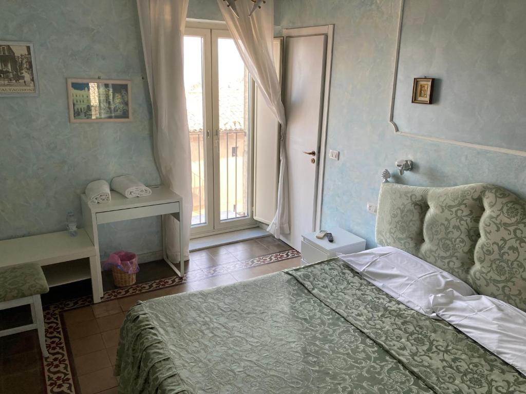 una camera con un letto e una grande finestra di loft nicoletta a Caltagirone