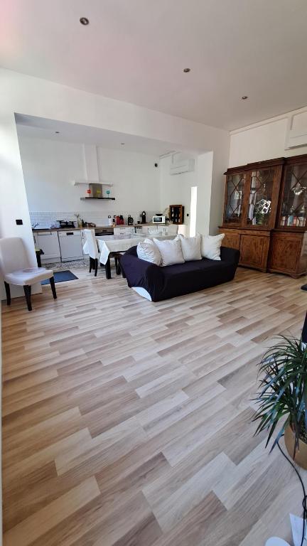 uma sala de estar com um sofá e um piso de madeira em Maison de charme, coeur de Douai em Douai