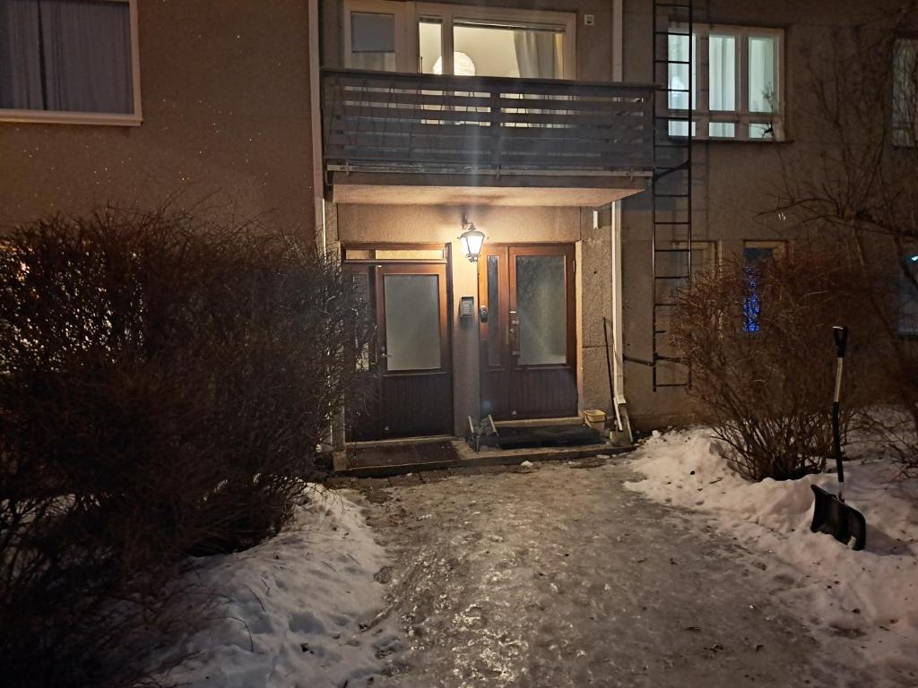 uma porta da frente de uma casa na neve à noite em Huoneisto Oppistan Kokkola em Kokkola