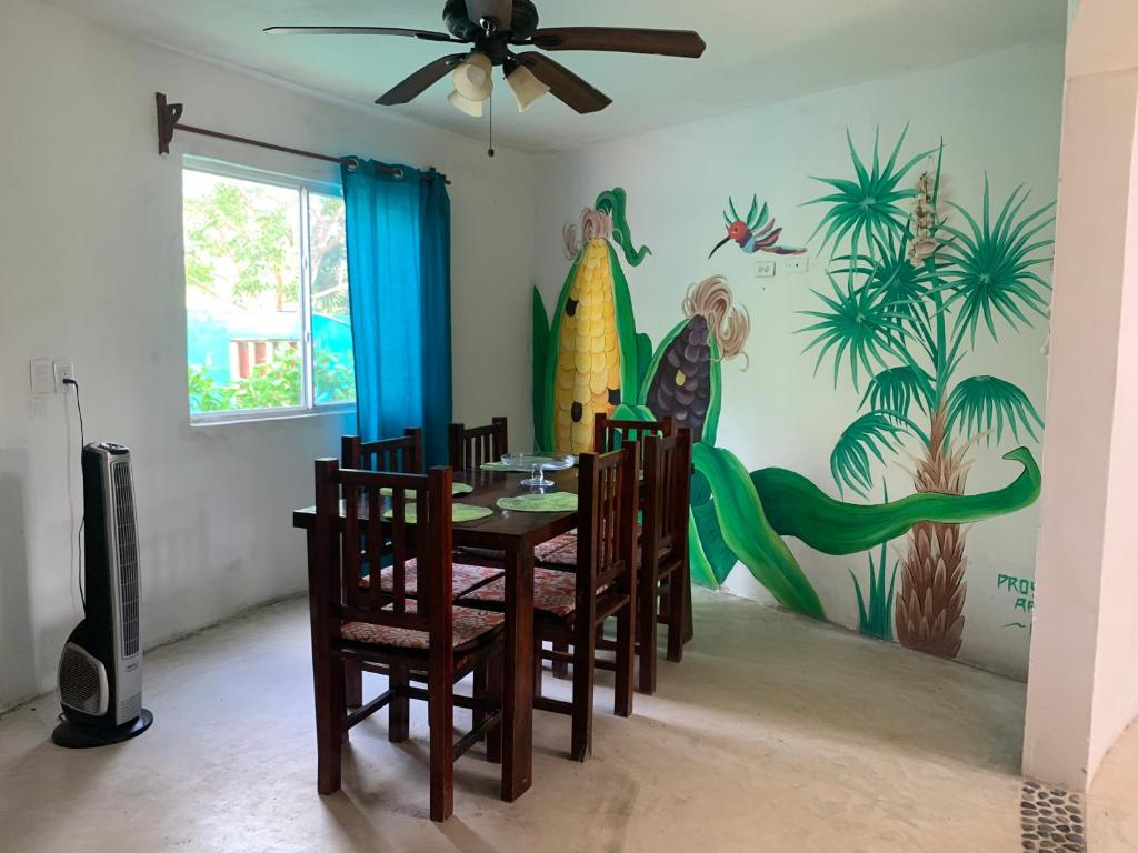 a dining room with a table and chairs and a mural at Casa Redonda Hostal Inn 1 in Holbox Island