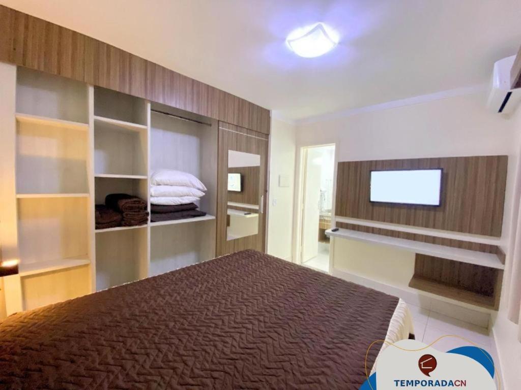 um quarto com uma cama e uma televisão de ecrã plano em L'acqua diRoma 12345 / CN - Adriele em Caldas Novas