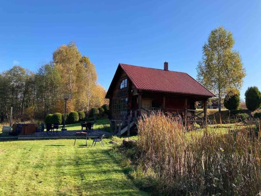 a small cabin in a field with a grassy field sidx sidx sidx at FOREST RIVER RESORT in Vilnius