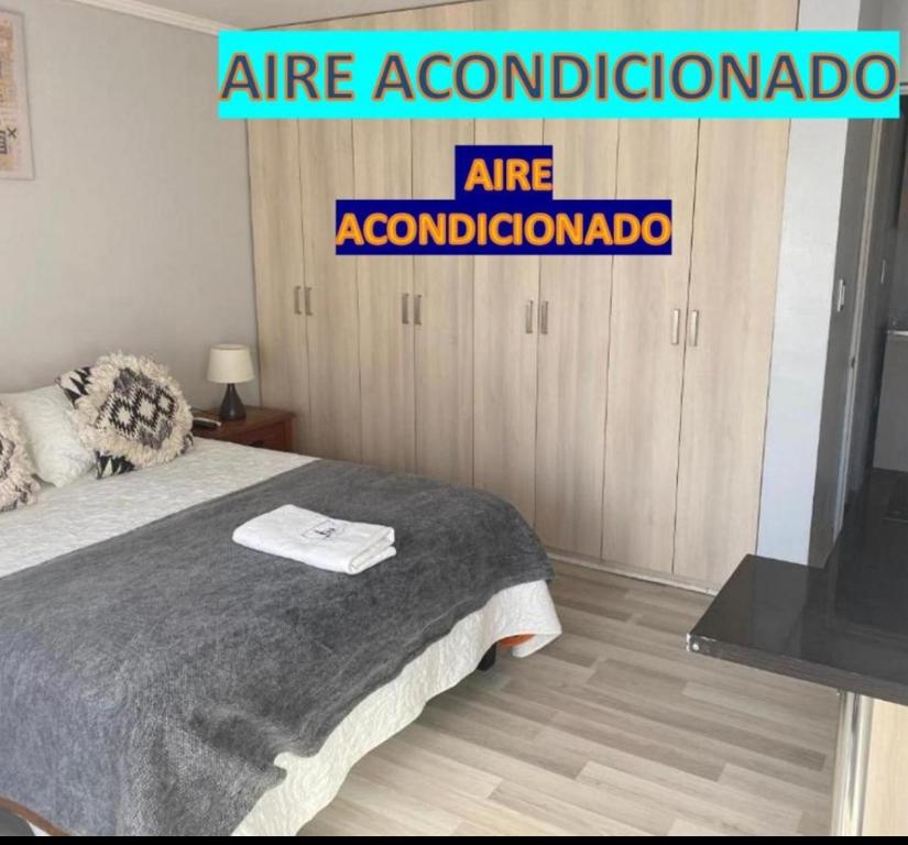 - une chambre avec un lit et un panneau indiquant l'hébergement dans l'établissement Departamento Studio - Carrera - Factura - Central - Empresas, à Chillán