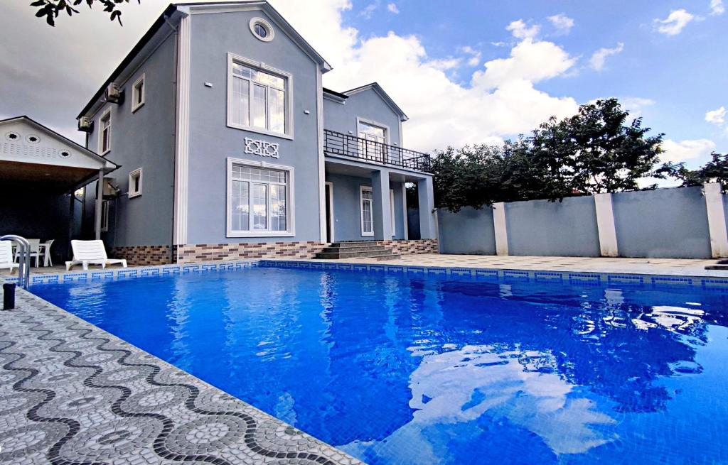 uma casa com piscina em frente a uma casa em Qafqaz Manor Zabbix em Gabala