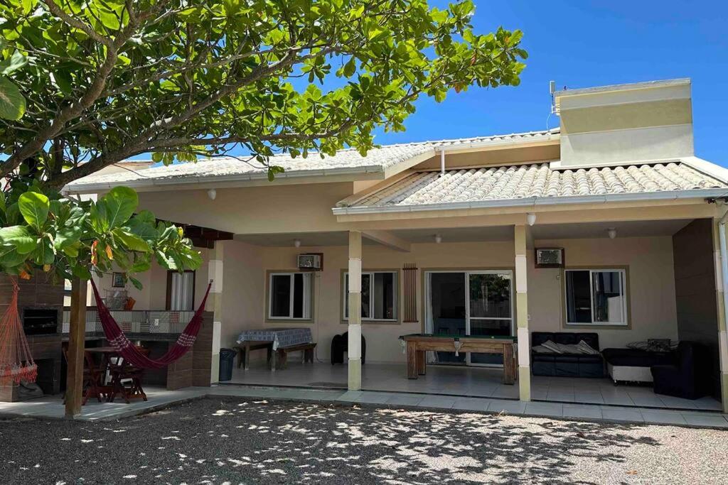 une maison avec une terrasse et une table en face dans l'établissement Casa de praia aconchegante, à Palhoça